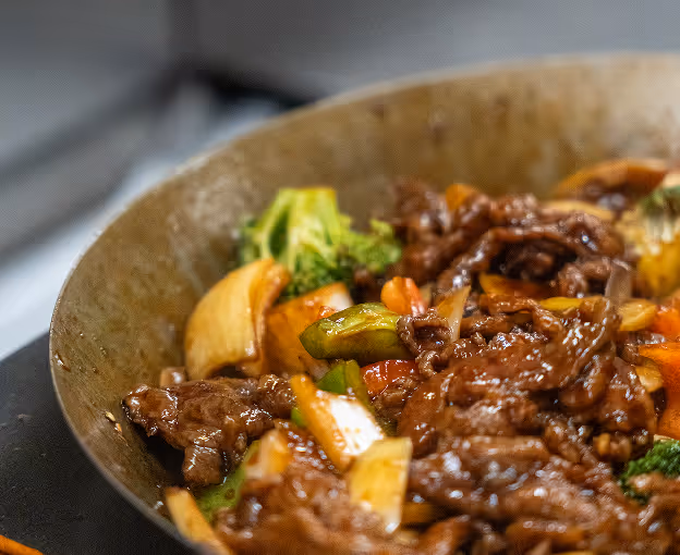 Beef stir-fry with vegetables in a hot wok.
