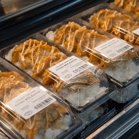 A display case filled with trays of food.