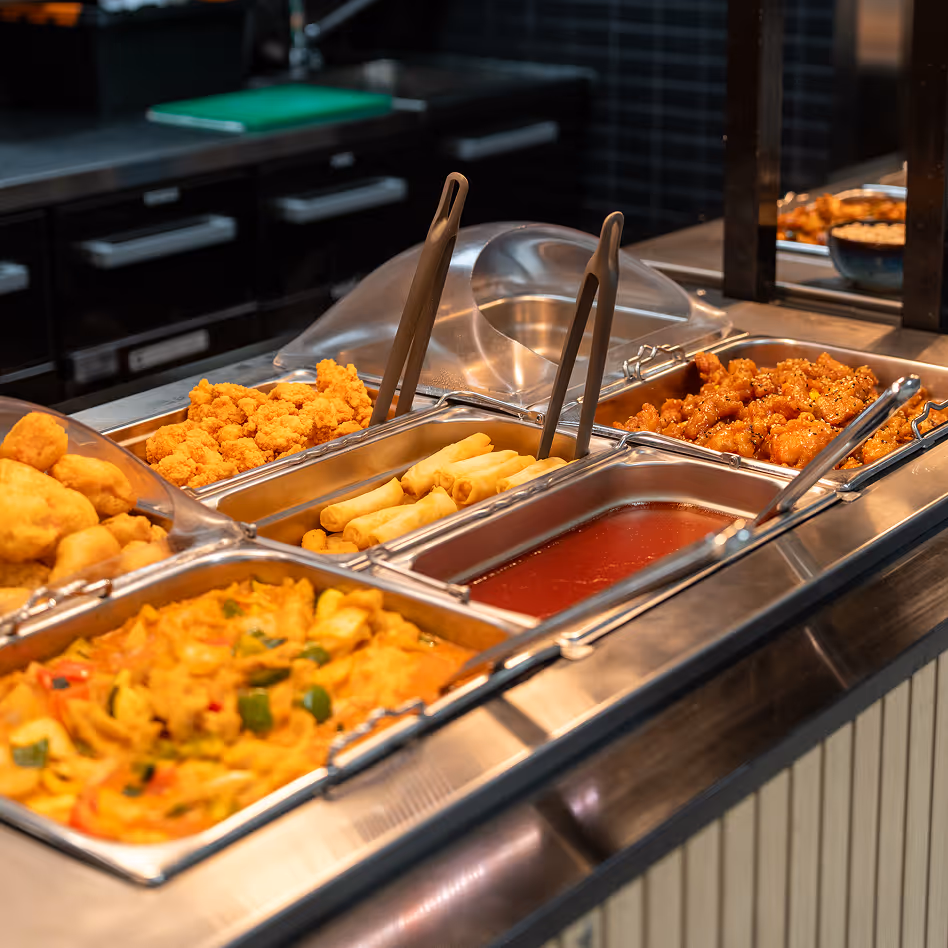 Hot food buffet with spring rolls, fried chicken, and curry.